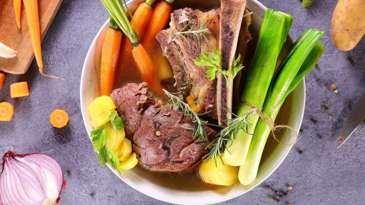 cuenco con ingredientes del ramen como hueso de vacuno, carne y puerro como base del ramen de ternera
